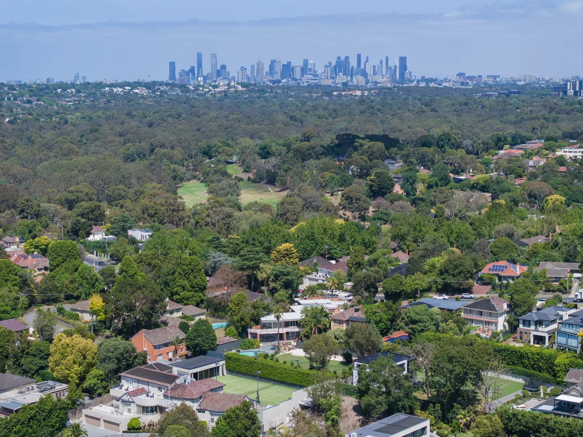 Aerial over the property to the city skyline