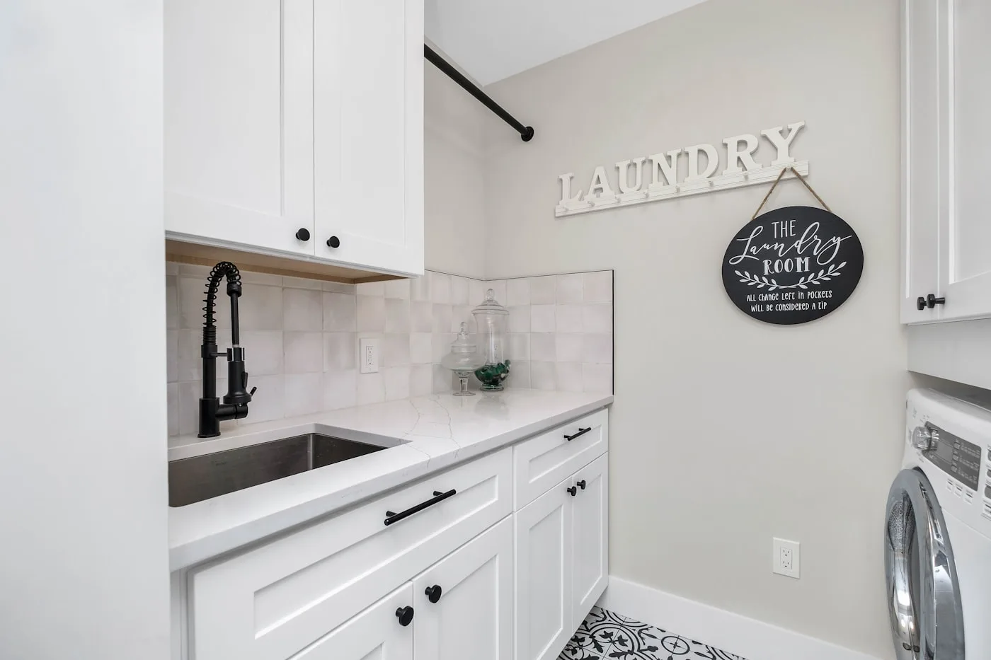 Completed laundry with custom cabinetry, stone benchtop and integrated sink